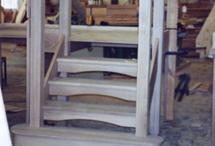 Open tread stairs with "eyebrow" half risers having posts dry fitted in workshop