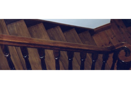 Stained softwood staircase with fluted elizabethan balastors and scrolled handrail.